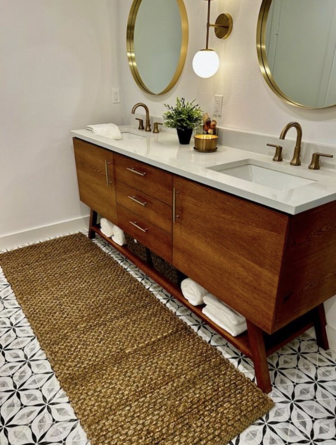 Double vanity bathroom remodel with wood cabinetry and round mirrors