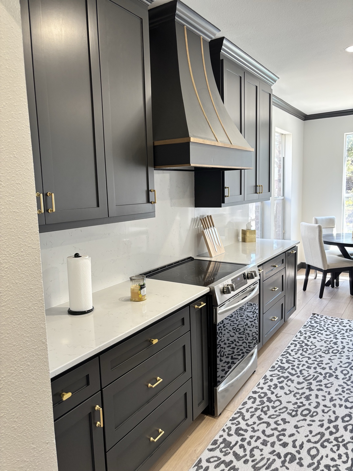Black kitchen remodel with gold hardware and custom range hood by Johnson Renovations